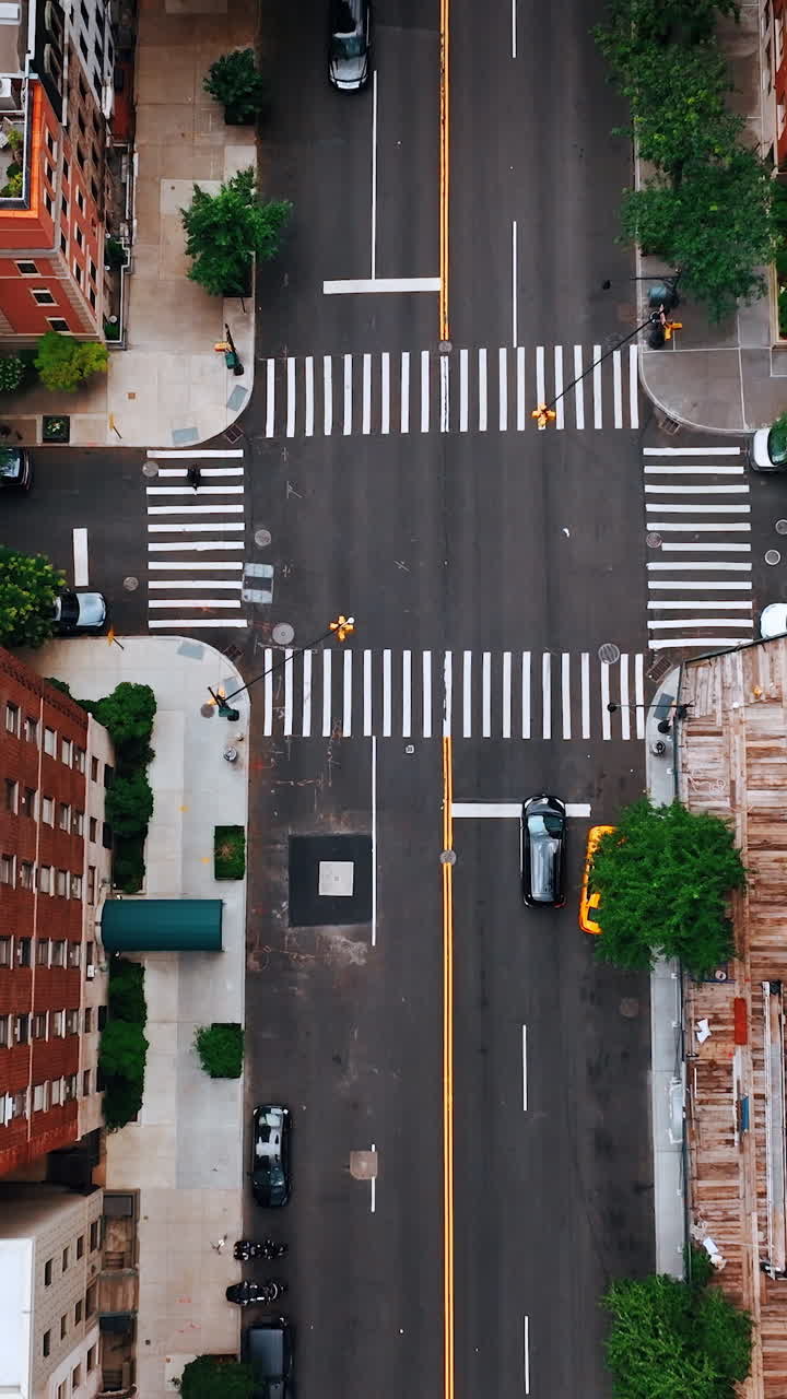 Going down over the usual crossroads in New York. View of building tops from above. Vertical video