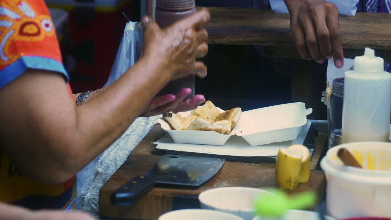 Riprese cinematografiche di cucina in 4K di uno chef thailandese che prepara un dolce tradizionale thailandese chiamato Roti in un mercato di strada in Thailandia