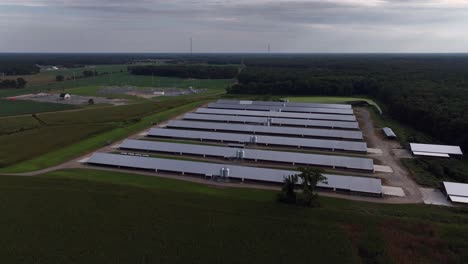 an aerial view of eight parallel farm buildings with metal roofs