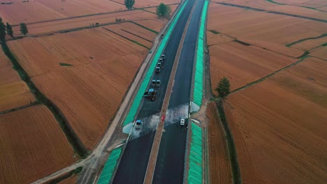aerial view of road construction at sunrise in bozhou, anhui province, china, surrounded by golden farmland, showcasing infrastructure development in progress