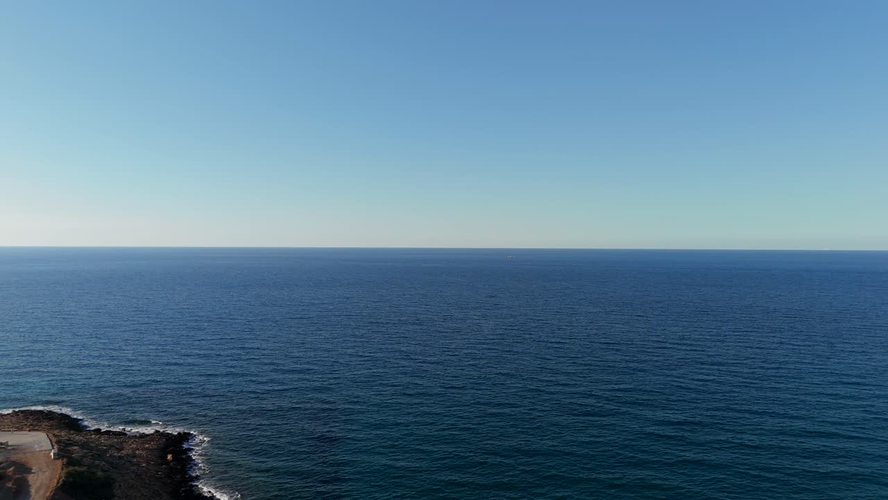 Expansive view of the tranquil blue sea stretching to the horizon under a clear sky in Crete, Greece