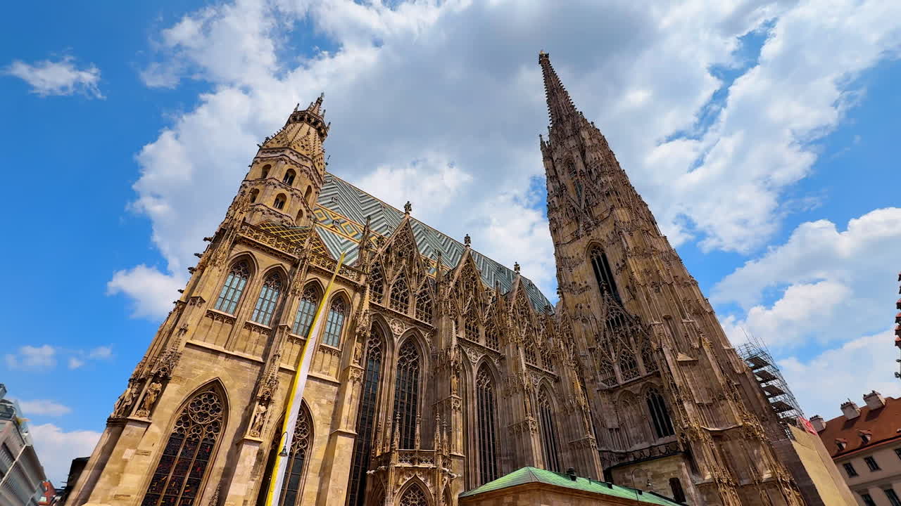 Vienna, Austria - June 9, 2025: Saint Stephen's Cathedral in Vienna, Austria. Low angle view at the stunning architectural masterpiece at the backdrop of blue sky and white cloudscape