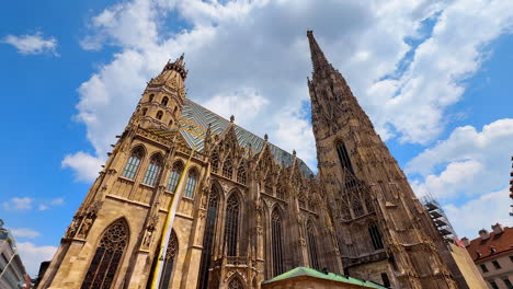 vienna, austria - june 9, 2025: saint stephen's cathedral in vienna, austria. low angle view at the stunning architectural masterpiece at the backdrop of blue sky and white cloudscape
