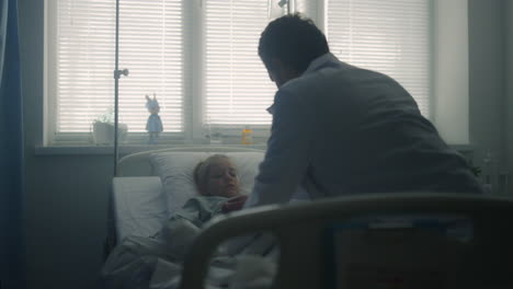 doctor doing medical examination of sick child modern pediatric hospital ward.