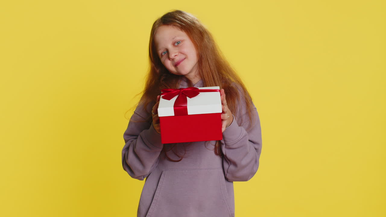 encantadora sonrisa preadolescente niña niña presentando caja de regalos de cumpleaños oferta envuelto regalo celebrando