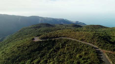 Luftaufnahme-Einer-Malerischen-Grünen-Bergstraße,-Meerblick,-Landschaft-Bei-Sonnenuntergang