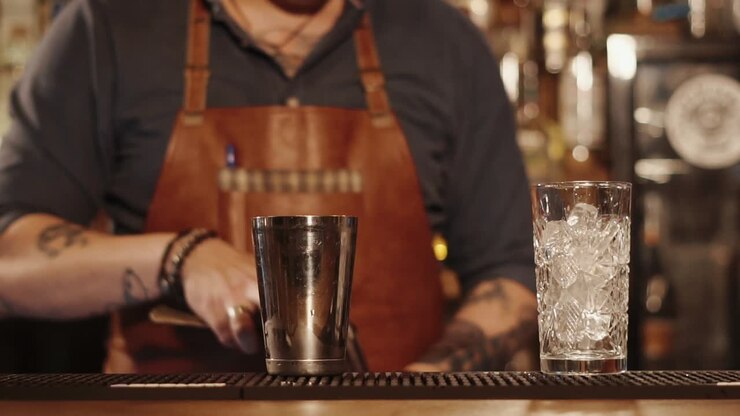 Barista che prepara un cocktail in un bar