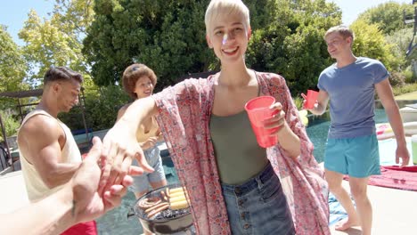 Portrait-of-happy-diverse-group-of-friends-drinking-drinks-and-dancing-at-pool-party-in-summer