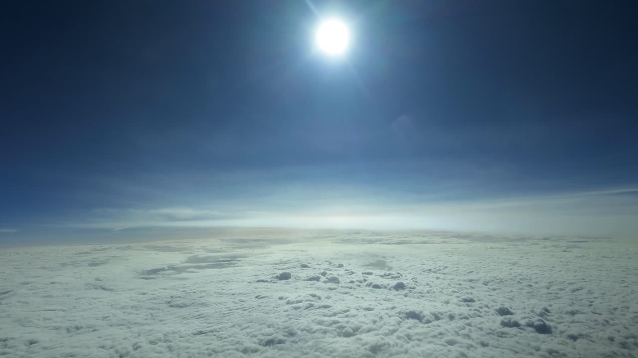 Esclusiva POV del pilota che vola sopra un mare di nuvole a velocità supersonica con un sole bianco abbagliante davanti in un cielo blu