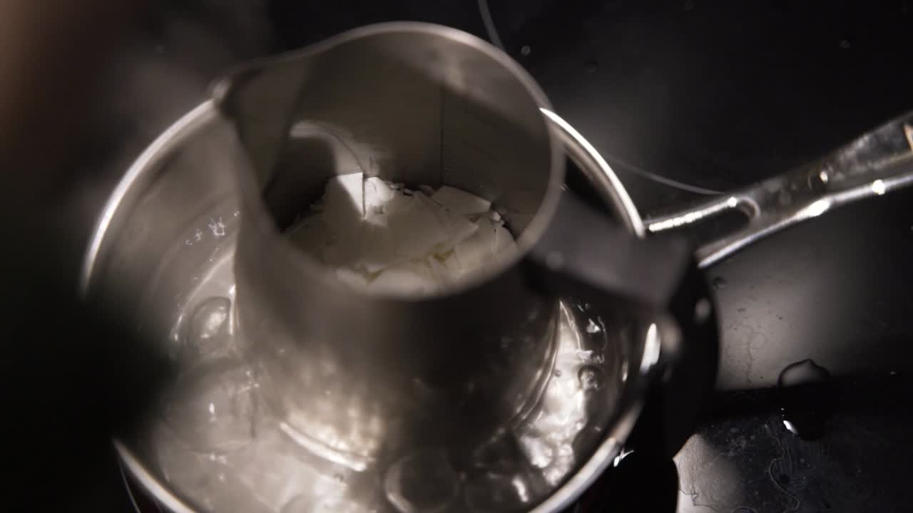 плавление парафина в кипящей воде для изготовления домашних свечей, близко