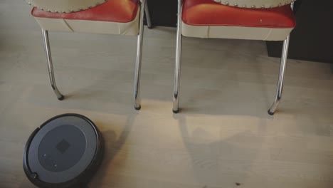 el robot aspirador está en el proceso de limpiar el suelo - de cerca