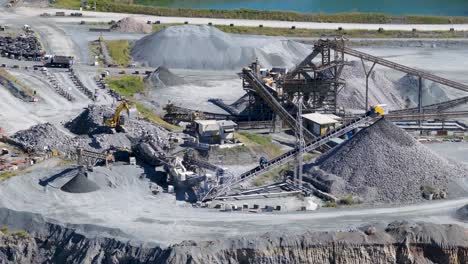 drone footage captures active mining operations at a gold coast quarry, showcasing machinery, trucks, and excavators under bright daylight