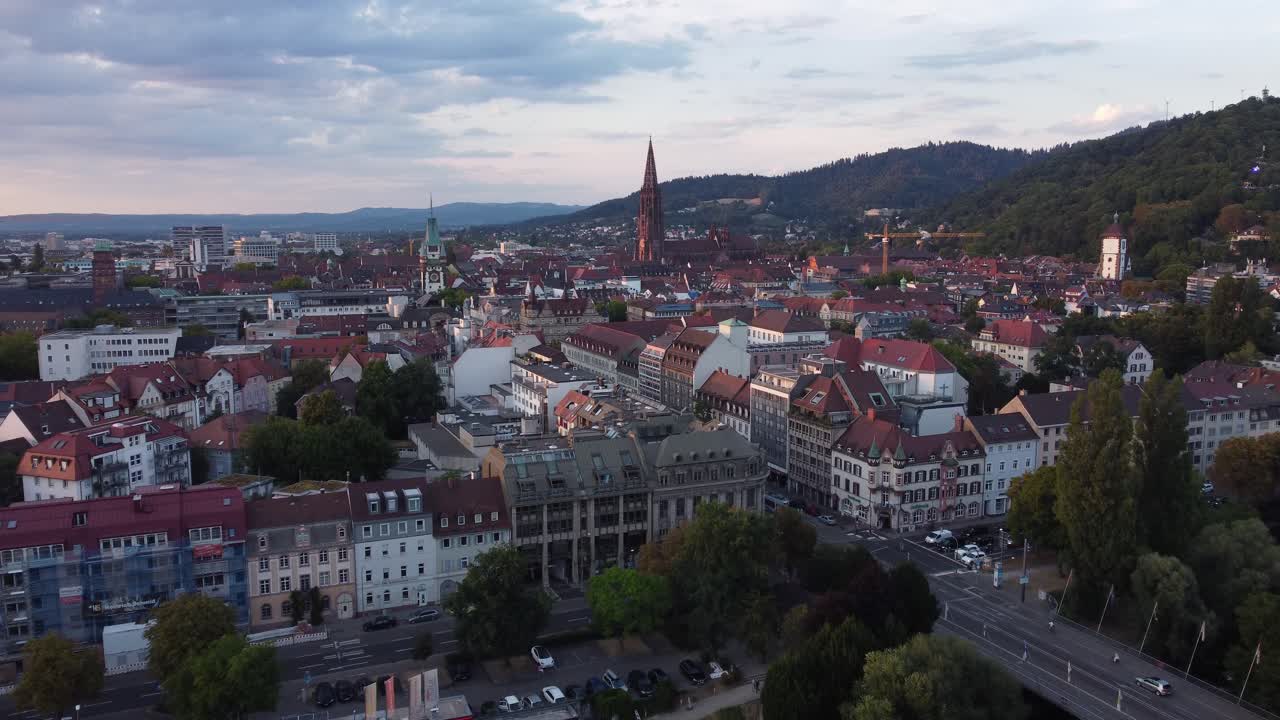 Cinematic aerial view of gothic old town landscape of Freiburg im Breisgau during sunset, Germany
