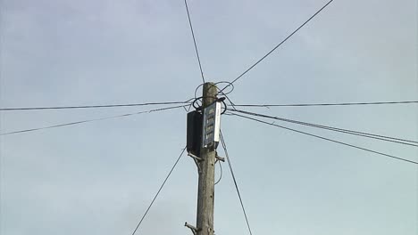 close up to wide angle of a wooden telegraph pole in an english town