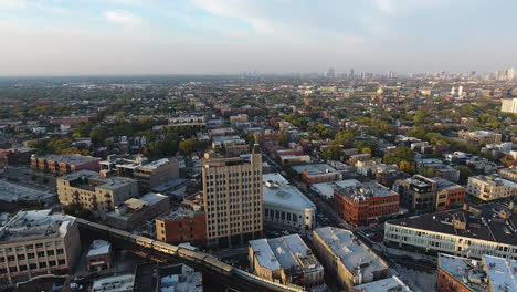 Vista-Aérea-Del-Tren-De-La-Línea-Azul-Del-Metro-De-Chicago-Pasando-Por-El-Barrio-De-Bucktown,-Revelando-Un-Disparo-De-Un-Dron