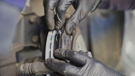 mechanic changing brake pads on a car wheel