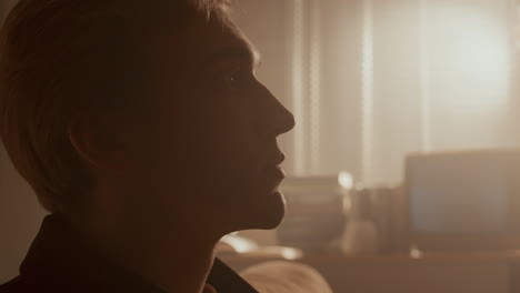 young man turning on vintage boombox, listening to music in sunlit room
