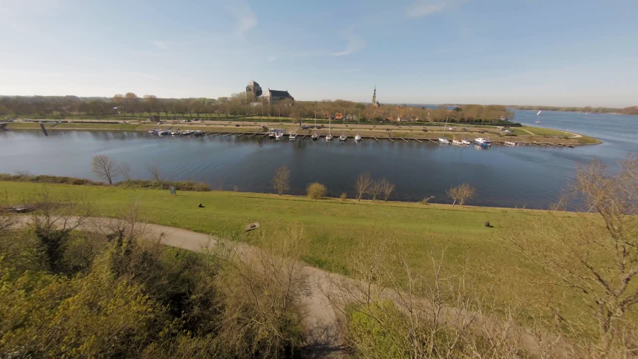 Aerial drone crane shot of green public park by canal near Veere medieval town