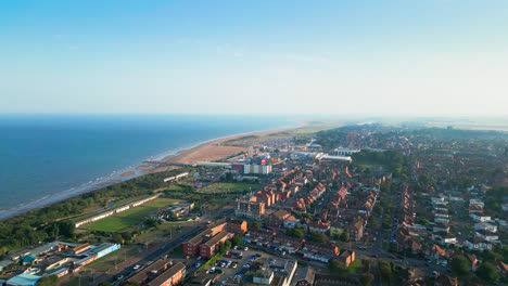 Dieses-Luftvideo-Zeigt-Skegness,-Ein-Küstenjuwel-In-Lincolnshire,-Mit-Seinem-Langen-Sandstrand,-Dem-Geschäftigen-Touristenviertel,-Den-Fahrgeschäften-Und-Dem-Berühmten-Pier-An-Einem-Sommerabend