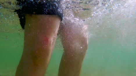 hombre caucásico sumerge la cabeza en el lago para lavar el cabello, cámara lenta bajo el agua