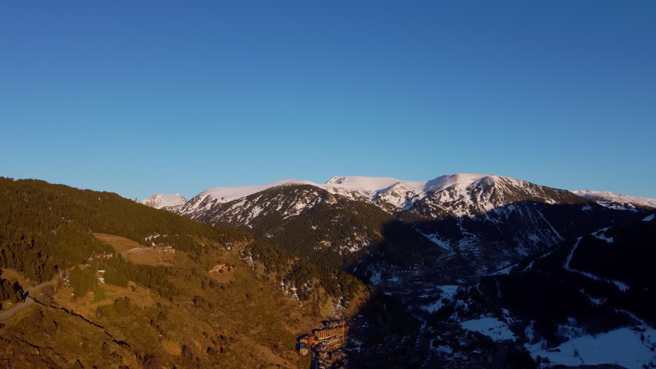 4K Drone Approach to Snowy Valley and Mountain Slopes with Forest and Village in Andorra at Sunset