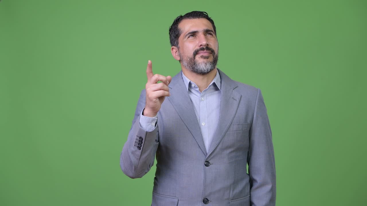 Handsome Persian bearded businessman pointing finger up