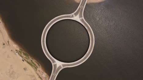 High-top-down-view-of-the-laguna-Garzon-circular-bridge-above-the-deep-island-flowing-water-in-Uruguay,-south-America