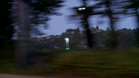 un automóvil viaja a lo largo de la autopista de la costa del pacífico temprano en la mañana o tarde en la noche como se ve a través de la ventana lateral 1