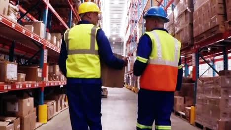 two warehouse workers interacting with each other