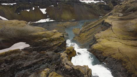 disparo de drones volando sobre una gran cascada con la cámara inclinada hacia abajo en islandia 4k