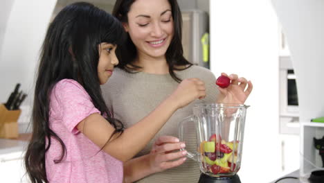 madre e hija cocinando frutas en la cocina