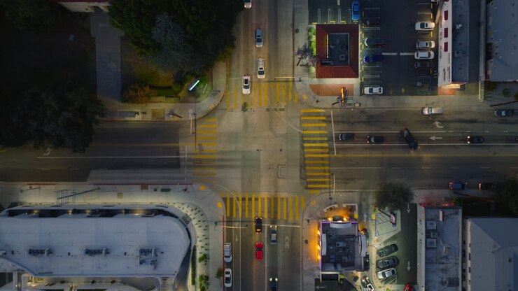 Neighborhood Traffic as Seen From Above, Birds Eye Shot of Cars Moving Through Intersection in Early Evening
