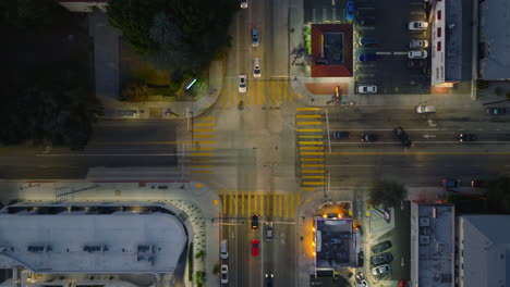 Neighborhood-Traffic-as-Seen-From-Above,-Birds-Eye-Shot-of-Cars-Moving-Through-Intersection-in-Early-Evening