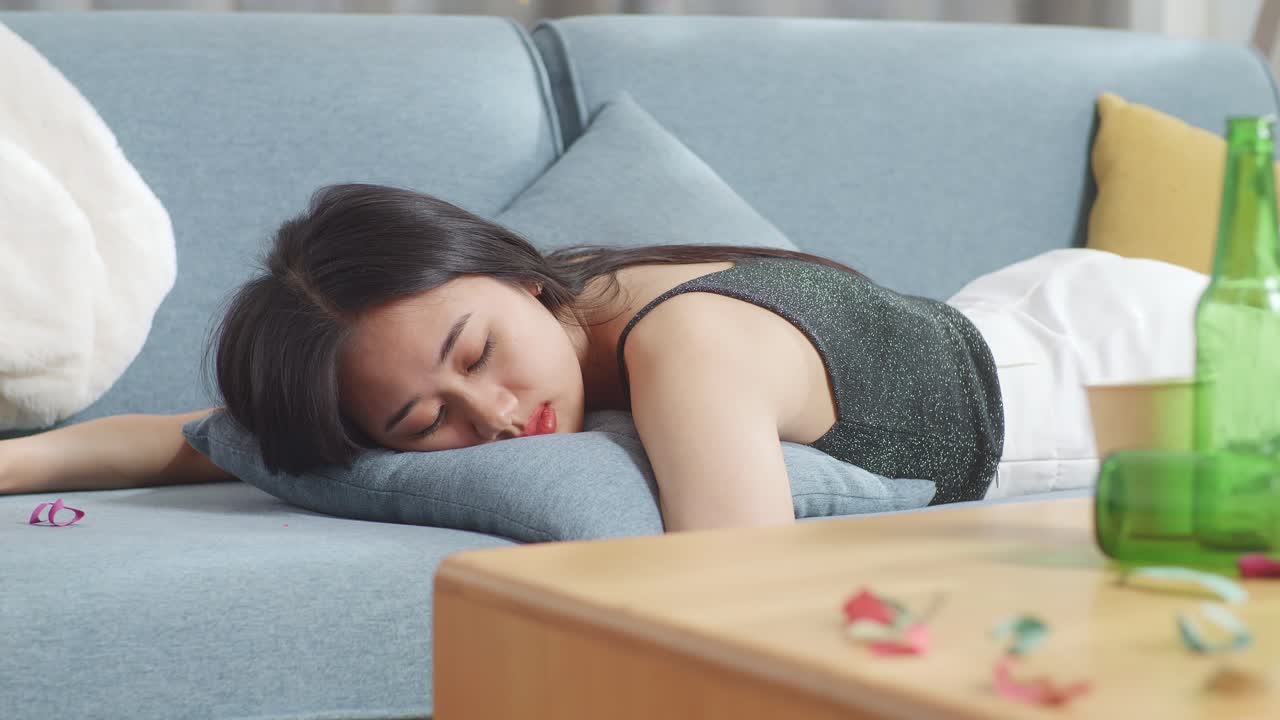 술에 취한 여자가 파티 후 소파에서 잠을 자고 있다