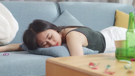 술에 취한 여자가 파티 후 소파에서 잠을 자고 있다