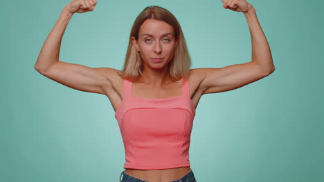 mujer mostrando bíceps y pareciendo confiada, sintiendo poder fuerza para luchar por los derechos, el éxito ganar