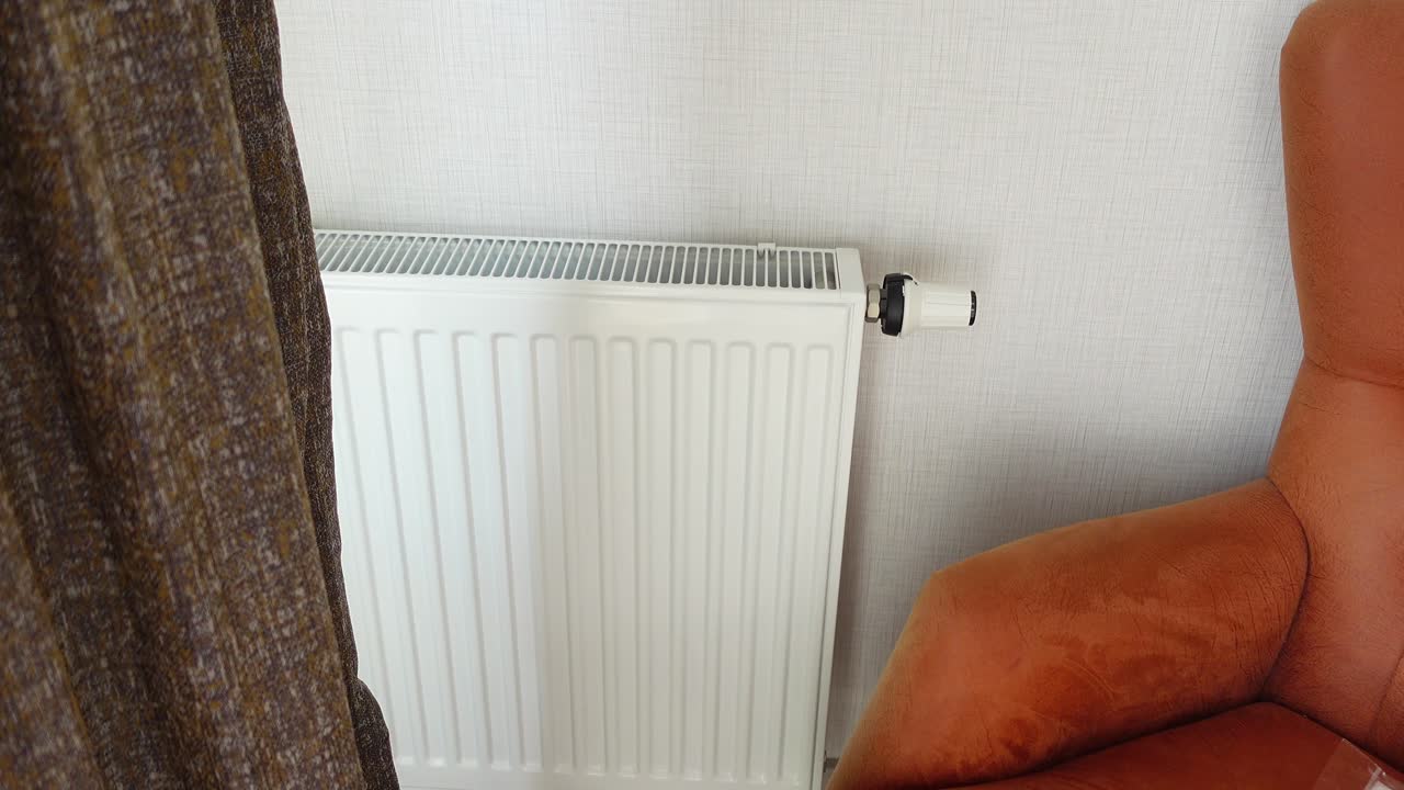 색 라디에이터와 방에 있는 갈색 의자의 클로즈업