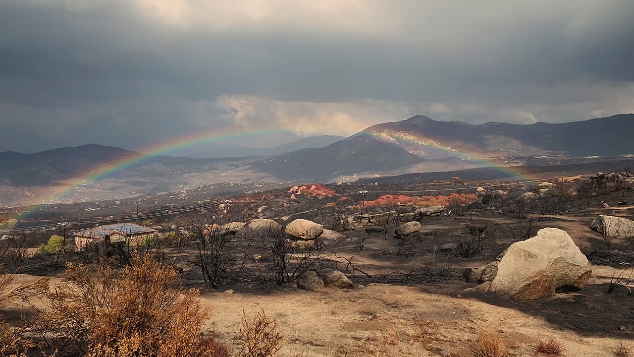 vista panorámica del valle quemado con lluvia y arco iris en el cielo