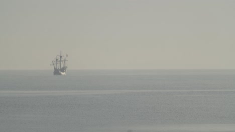 Ferdinand-Magellan-Nao-Victoria-carrack-boat-replica-with-spanish-flag-sails-in-the-mediterranean-at-sunrise-in-calm-sea-in-slow-motion-60fps