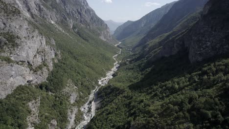 video drone dell'aereo frontale che sale tra le colline della valle del valbone e sopra la strada azem hajdariy e il fiume