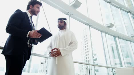 hombres de negocios árabes caucásicos occidentales se reúnen usando tableta