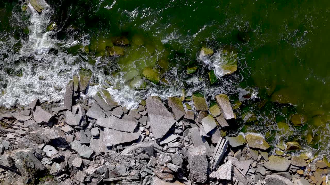 Vista aerea di una costa rocciosa con onde che si infrangono sugli scogli