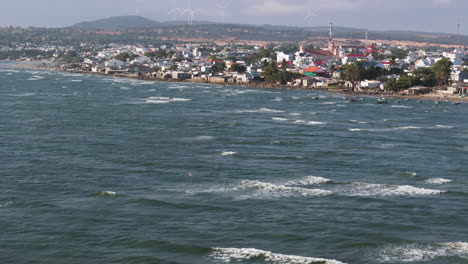 Drohnenaufnahme-Zeigt-Den-Küstenfischerort-Mui-Ne,-Der-Für-Windsurfen,-Kitesurfen,-Segeln-Und-Andere-Wassersportarten-Bekannt-Ist