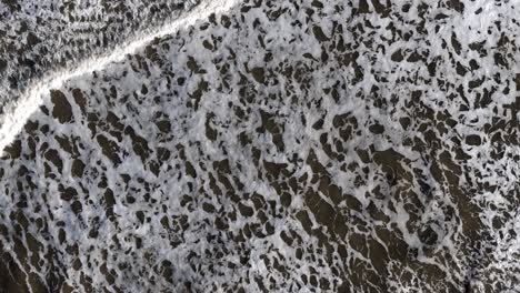 Aerial-shot,-bird-eye-view-of-waves-crashing-in-the-north-sea-off-scarborough