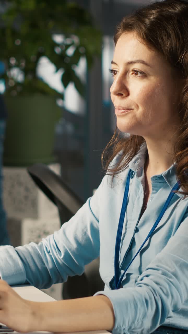 Vertical video Employee at office desk typing on keyboard, editing documents on computer