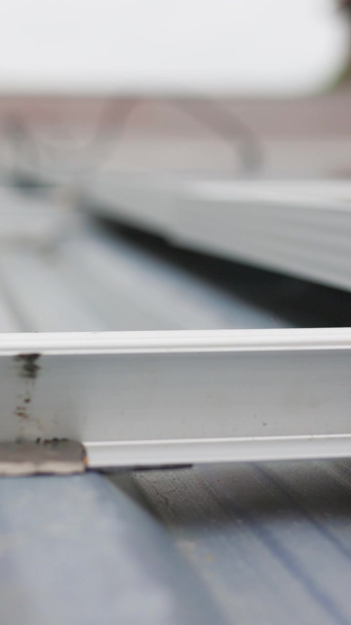 Vista ravvicinata dell'hardware di montaggio di un pannello solare, che mostra il telaio metallico e i componenti di fissaggio.