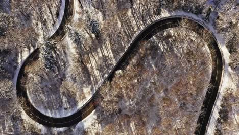 timelapse of serpentine driving cars at a winter landscape filmed by a drone and a look up shot to a wonderful white monastery