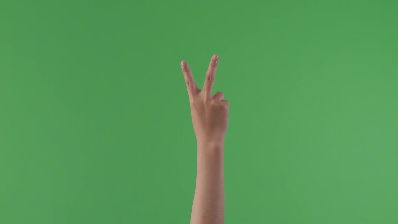 녹색 스크린에 평화의 표지판을 만드는 손