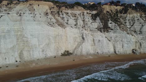 pull away from white cliffs and waves on slender beach in the mediterranean sea
