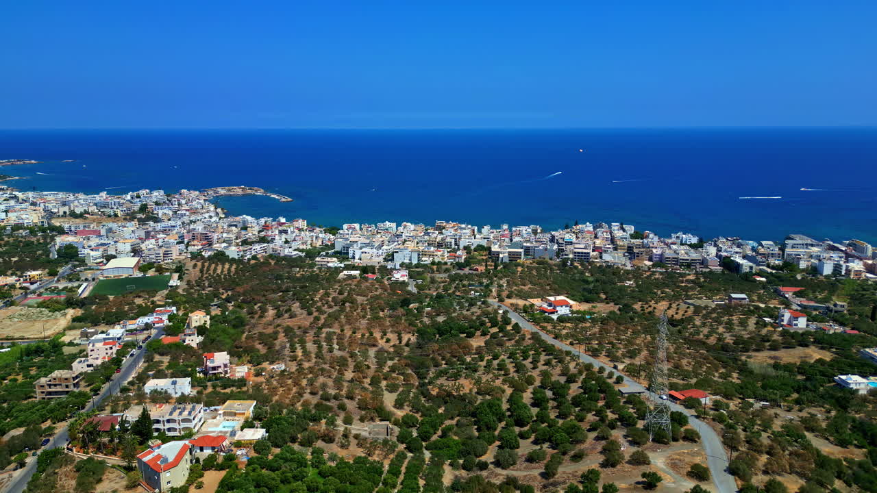 Aerial establishing dolly overview of Piskopiano, Greece, shrubs along hillside down to crowded coast with homes